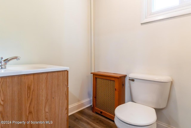 bathroom with hardwood / wood-style floors, vanity, and toilet