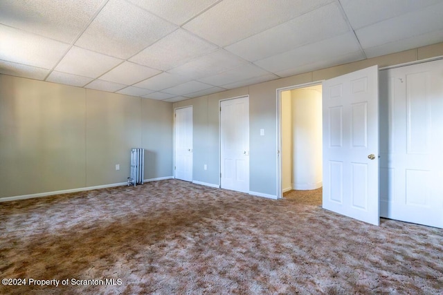 interior space featuring carpet flooring and a paneled ceiling