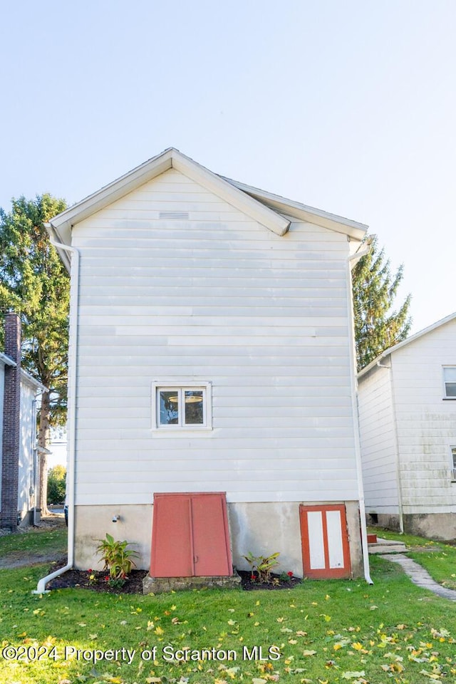 back of house featuring a lawn