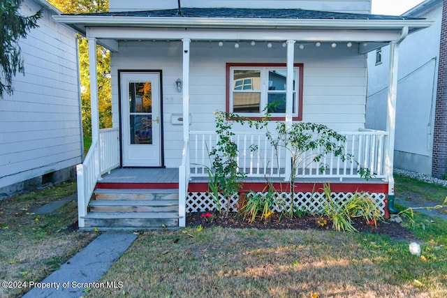 view of exterior entry with covered porch