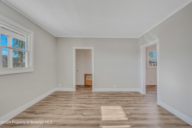 empty room featuring crown molding and light hardwood / wood-style flooring