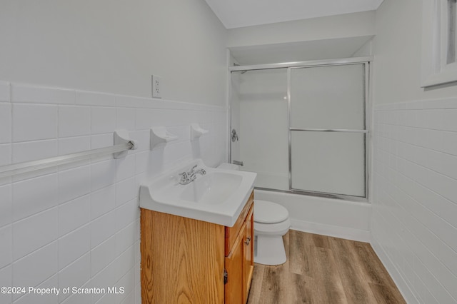 full bathroom with hardwood / wood-style floors, vanity, toilet, and tile walls