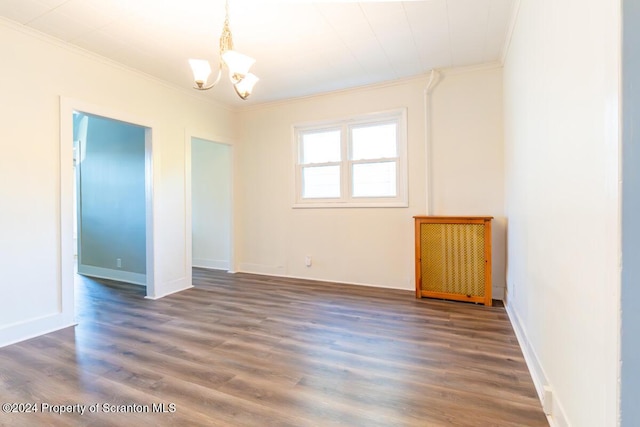 spare room featuring ornamental molding, dark hardwood / wood-style floors, and a notable chandelier