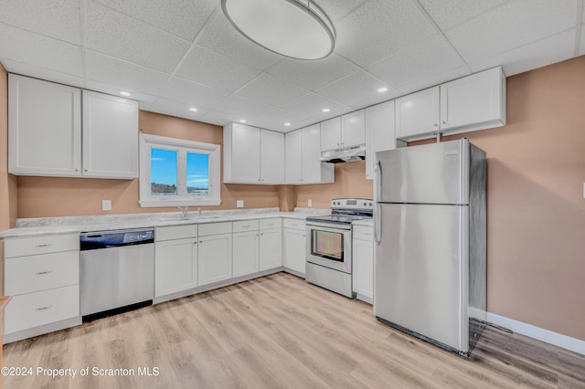 kitchen featuring white cabinets, stainless steel appliances, a drop ceiling, and sink