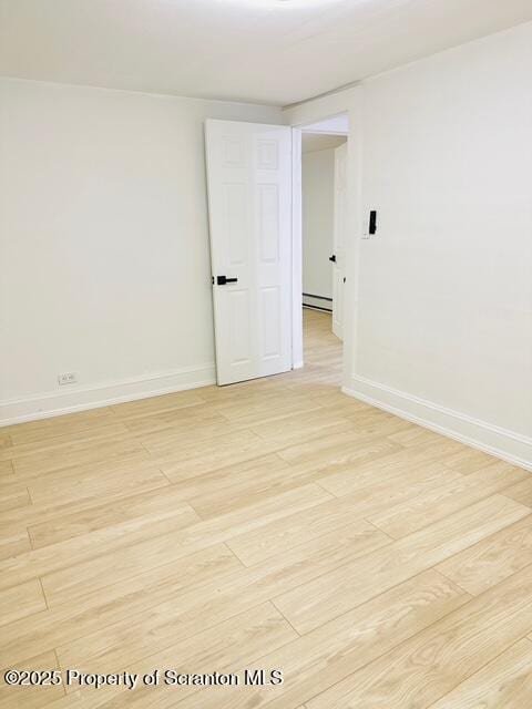 unfurnished room featuring light hardwood / wood-style flooring and a baseboard radiator