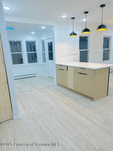 kitchen featuring decorative light fixtures, a baseboard radiator, ornamental molding, and light brown cabinets