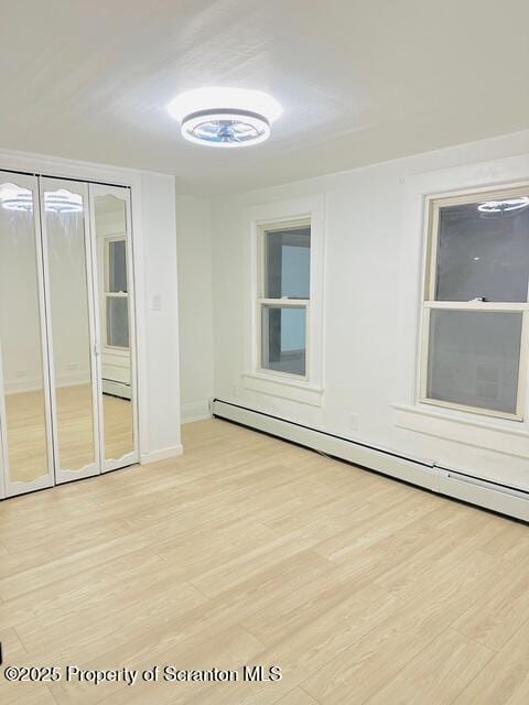 spare room with light hardwood / wood-style flooring and a baseboard radiator