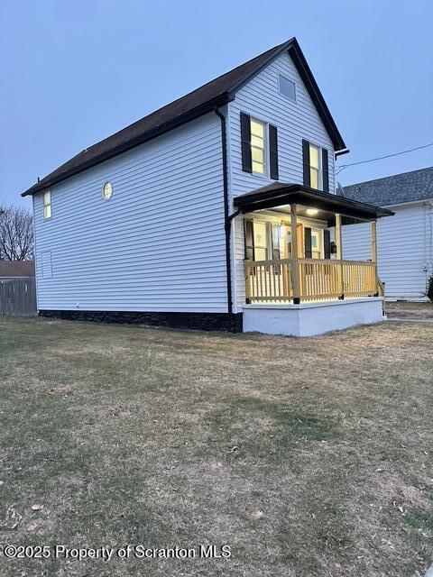 exterior space featuring covered porch and a lawn