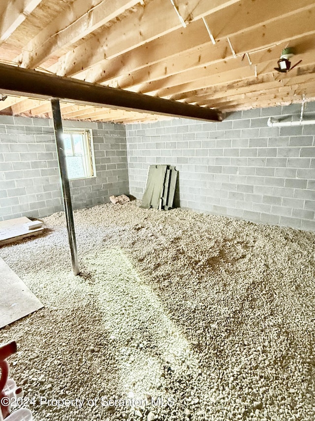 basement with wood ceiling and brick wall