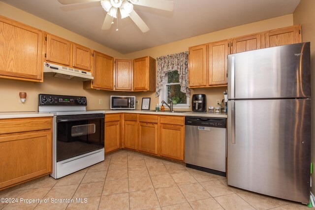 kitchen with light tile patterned flooring, appliances with stainless steel finishes, ceiling fan, and sink