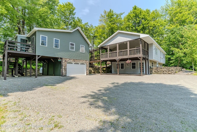 977 Laurel Ln, Kingsley, PA 18826 - view of front of property featuring a deck, a garage, gravel driveway, stairway, and stone siding