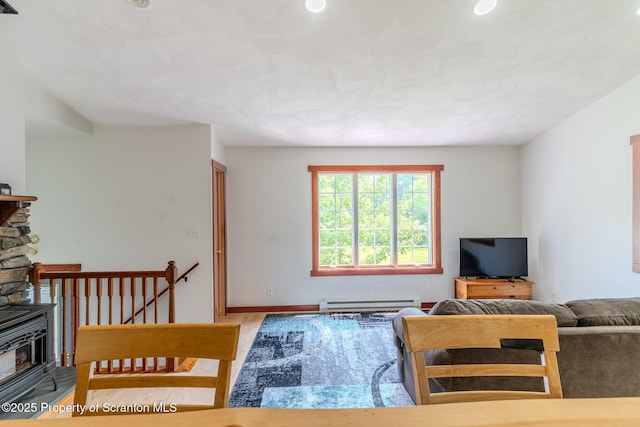 977 Laurel Ln, Kingsley, PA 18826 - living room with a wood stove, a baseboard heating unit, and wood finished floors