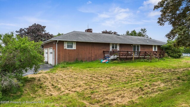 5 Patti Ann Dr, Scott Twp, PA 18433 - back of property with a wooden deck, a yard, a garage, a chimney, and asphalt driveway
