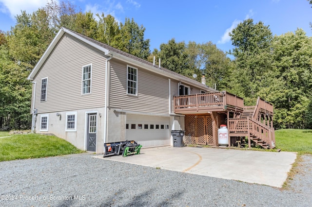 front of property with a wooden deck, a front lawn, and a garage