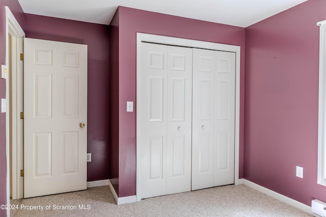 unfurnished bedroom featuring baseboard heating and a closet