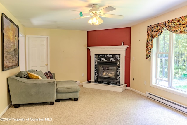 living room with carpet flooring, a premium fireplace, ceiling fan, and a baseboard radiator