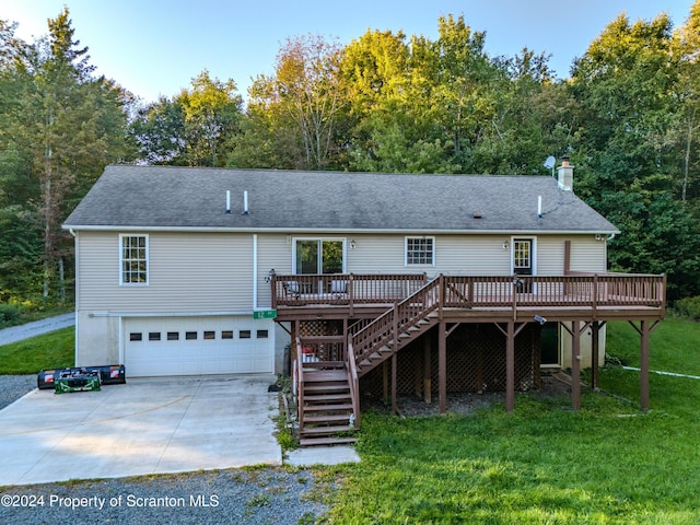 back of house featuring a wooden deck, a yard, and a garage