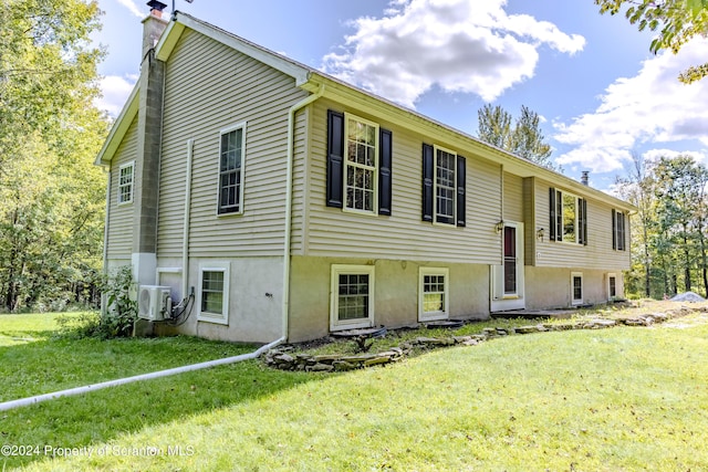 view of front facade with ac unit and a front lawn