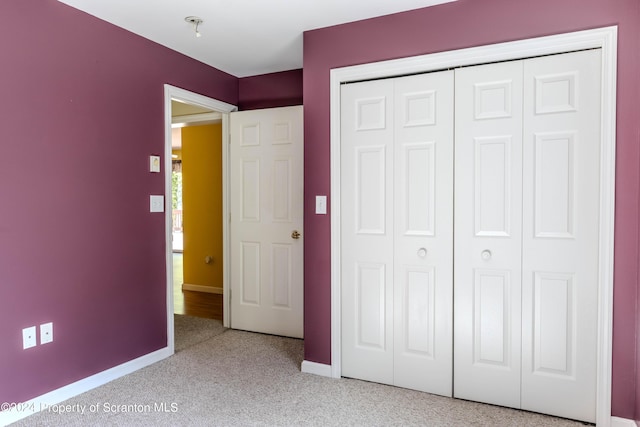 unfurnished bedroom featuring light colored carpet and a closet