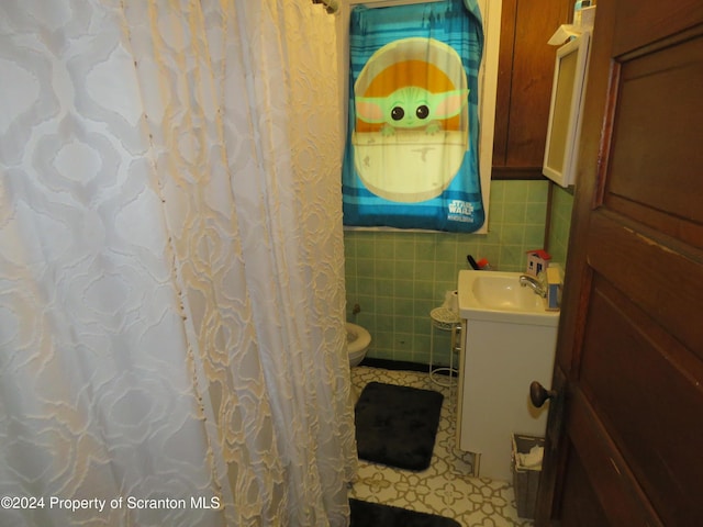 bathroom with tile patterned flooring, vanity, tile walls, and toilet