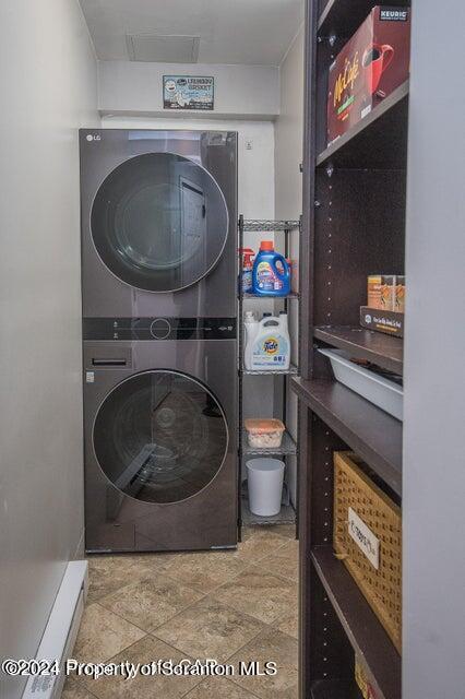 washroom featuring stacked washer and clothes dryer