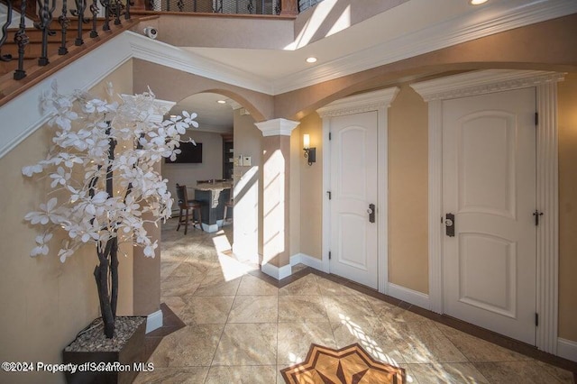 entrance foyer with decorative columns and crown molding