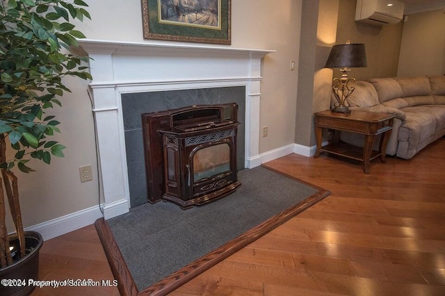 interior details featuring a wall unit AC, a wood stove, and hardwood / wood-style flooring