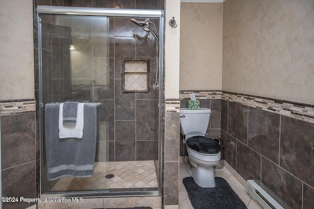 bathroom featuring baseboard heating, a shower with door, tile walls, and toilet