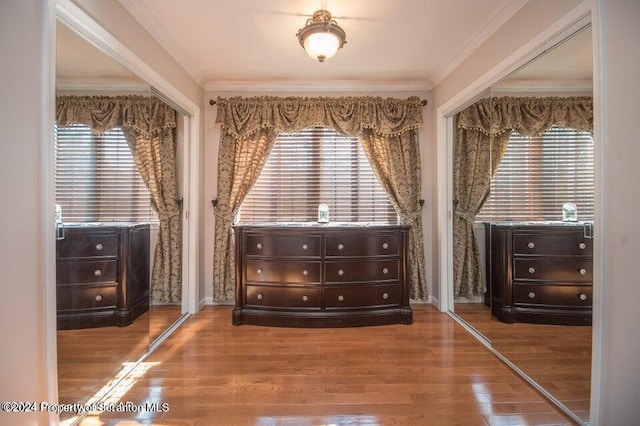 unfurnished bedroom featuring multiple windows, hardwood / wood-style floors, and a closet