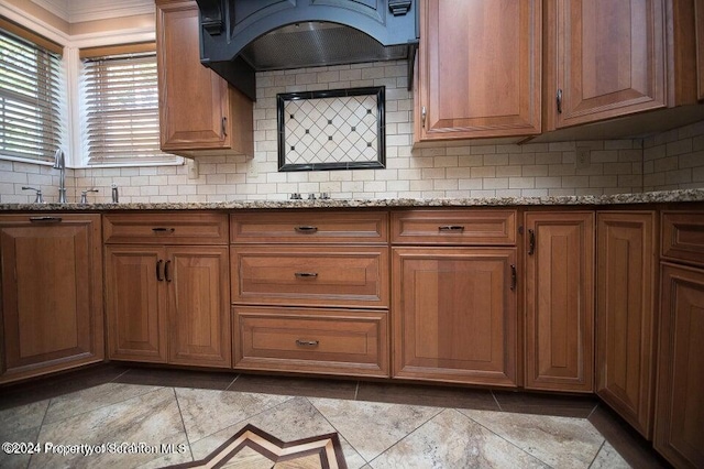 kitchen with light stone countertops, light tile patterned floors, tasteful backsplash, and sink