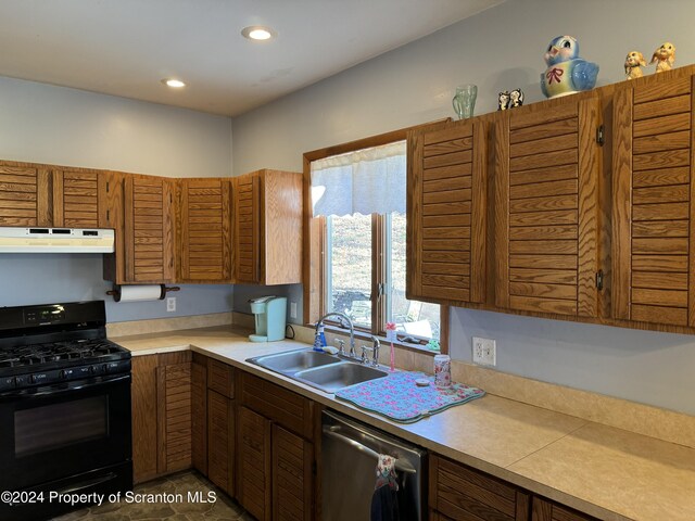 kitchen with under cabinet range hood, a sink, light countertops, stainless steel dishwasher, and black range with gas stovetop