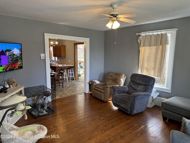 living room with ceiling fan and dark wood-type flooring