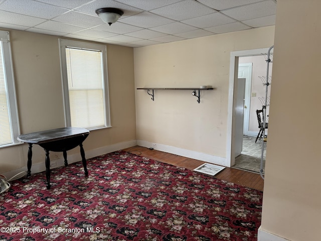 unfurnished room featuring a paneled ceiling and baseboards