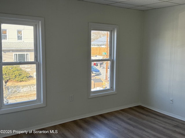 unfurnished room with dark hardwood / wood-style floors and a paneled ceiling