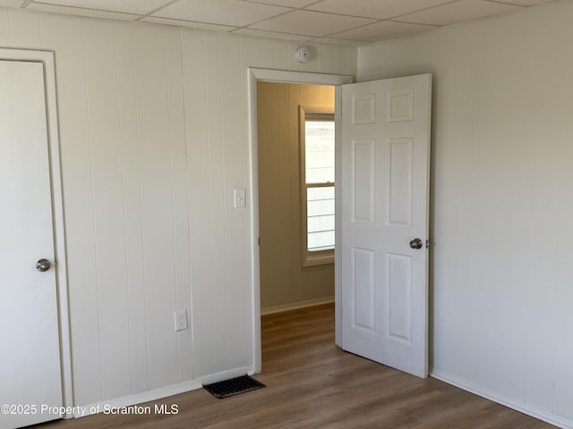 spare room featuring a paneled ceiling and wood-type flooring