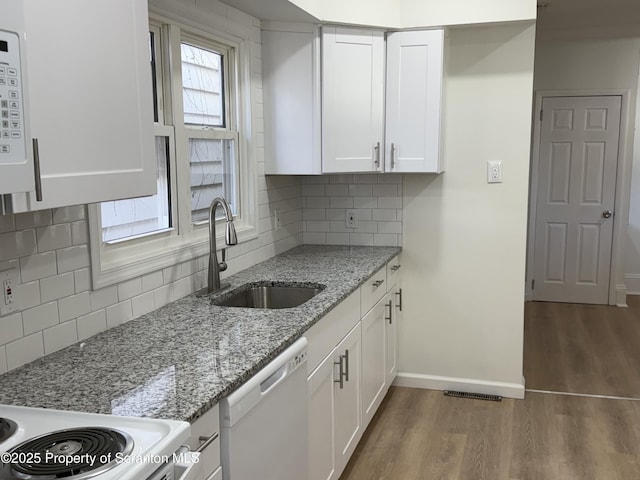 kitchen with white cabinetry, dishwasher, sink, and light stone counters