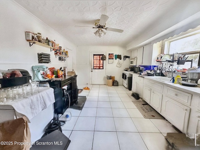 kitchen with sink, white appliances, ceiling fan, white cabinetry, and light tile patterned flooring