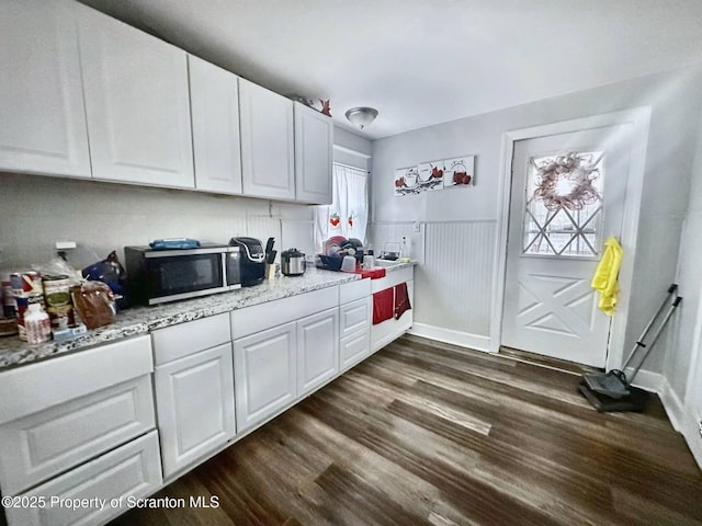 kitchen featuring light stone countertops, white cabinets, and dark hardwood / wood-style flooring