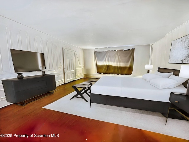 bedroom with ornamental molding and dark wood-type flooring