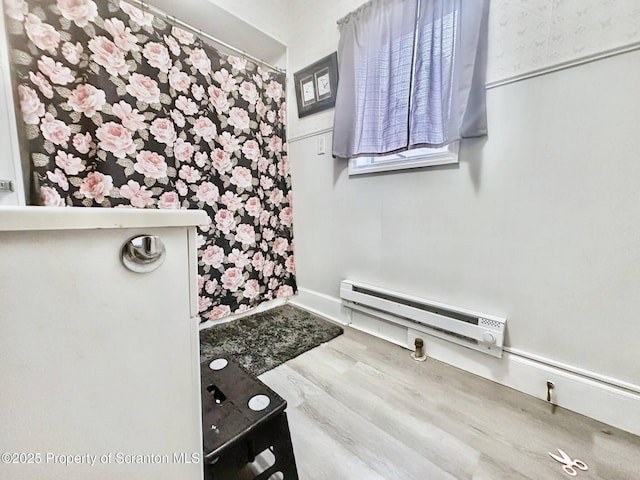 bathroom with a baseboard radiator and wood-type flooring