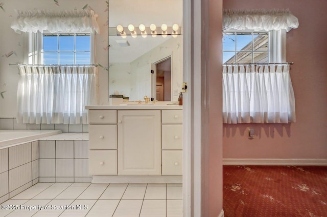 bathroom with tile patterned flooring, a garden tub, vanity, and baseboards