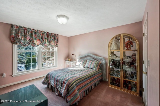 bedroom with carpet floors, a textured ceiling, and baseboards