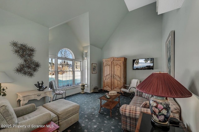 sitting room with high vaulted ceiling, dark colored carpet, and baseboards