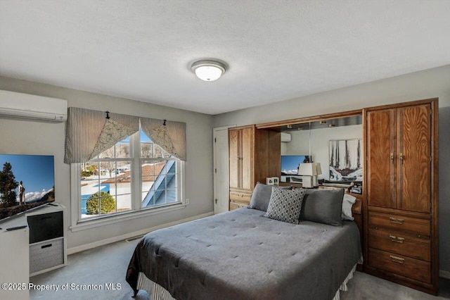 bedroom featuring baseboards, a wall unit AC, and light colored carpet