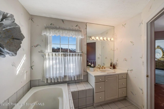 bathroom with a bath, a textured ceiling, tile patterned flooring, and vanity