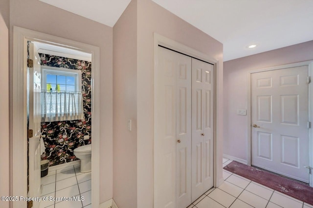 interior space featuring a closet, baseboards, toilet, and tile patterned floors