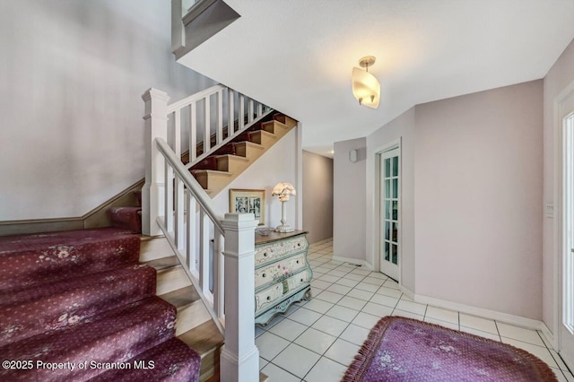 stairs featuring baseboards and tile patterned floors