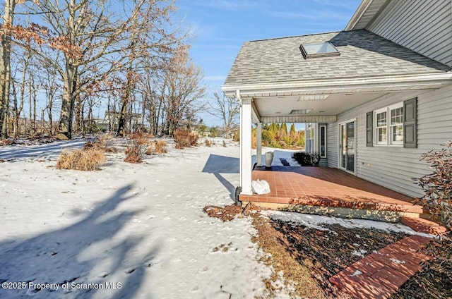 yard covered in snow with a porch