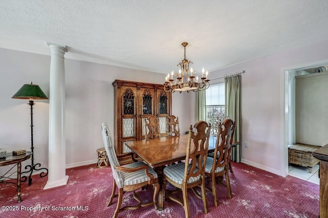 dining room featuring a chandelier, decorative columns, a textured ceiling, and baseboards