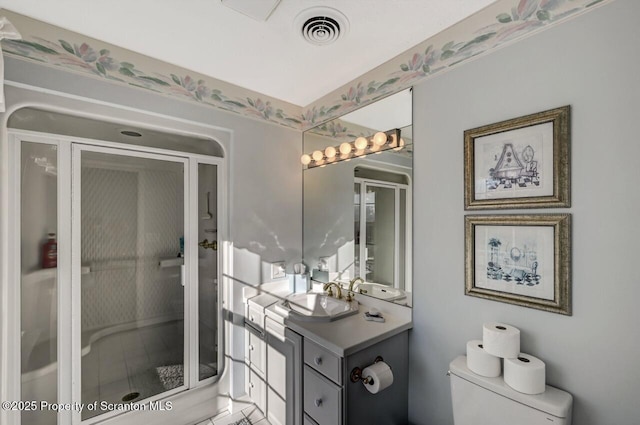 bathroom featuring a stall shower, visible vents, vanity, and toilet